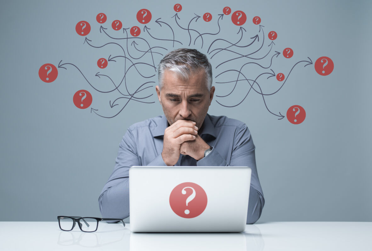Pensive,Businessman,Sitting,At,Desk,And,Working,With,A,Laptop,