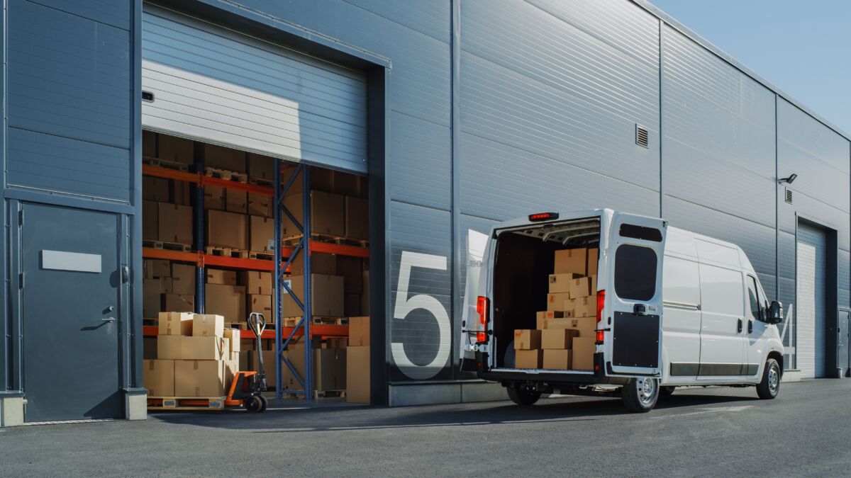 Outside,Of,Logistics,Warehouse,With,Open,Door,,Delivery,Van,Loaded