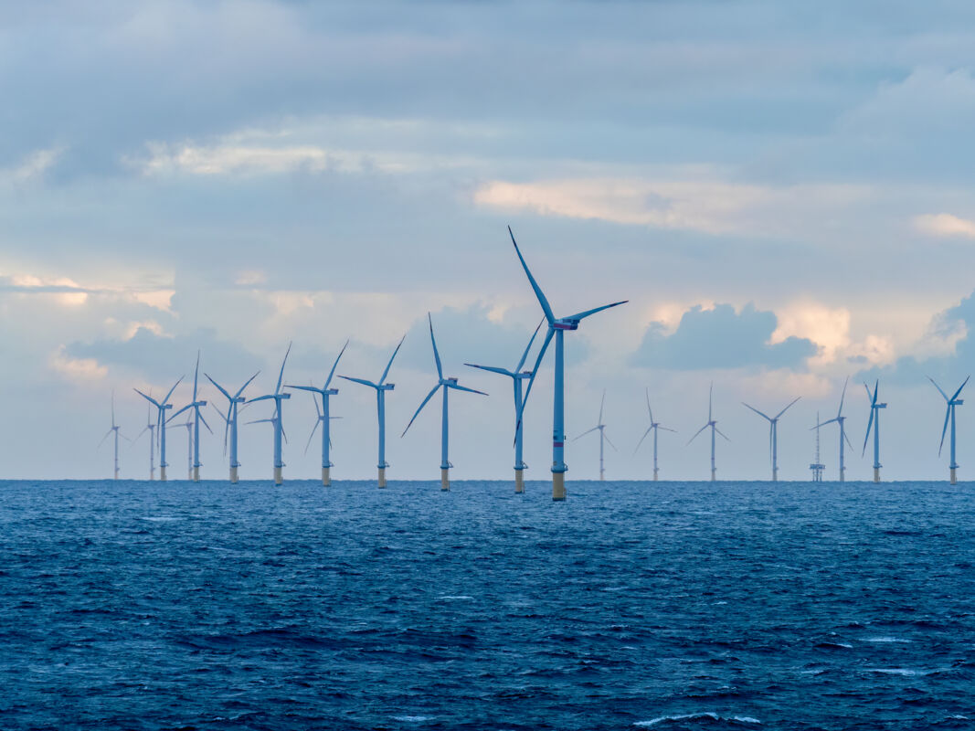 Offshore and Onshore Windmill farm Westermeerwind, Windmill park in the Netherlands with huge large wind turbines, group of windmills for renewable electric energy