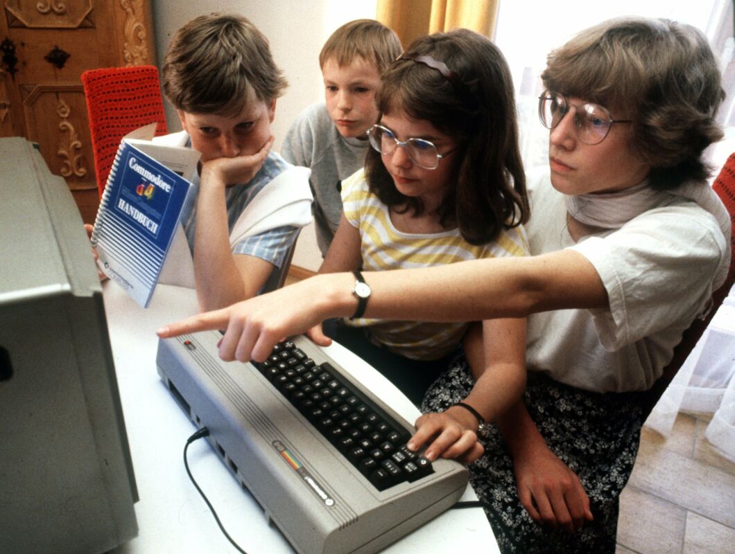 Adolescents try out a Commodore 64 in Nuremberg in May 1985.
