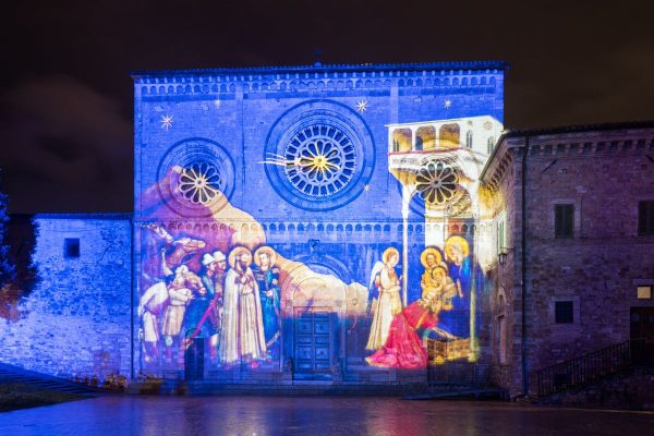 L'Adorazione dei Magi di Giotto proiettata con la luce sulla facciata dell'Abbazia di San Pietro ad Assisi.