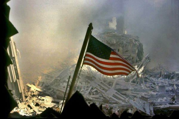 La bandiera americana sventola tra le macerie del World Trade Center a New York, alcune ore dopo l'attentato alle Torri Gemelle crollate a causa dell'impatto di due aerei dirottati dai terroristi islamici sulle Twin Towers, l'11 settembre 2001, New York. 
ANSA/  EPA/C'sar De Luca