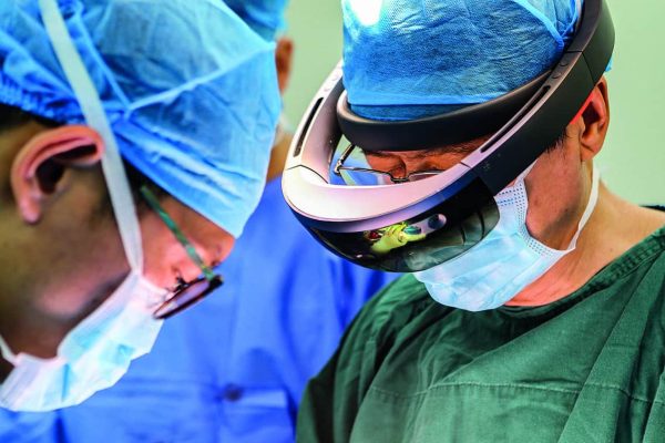 --FILE--Doctors wearing prescription glasses with Mixed Reality (MR) headsets do a surgery for a 15-year-old girl to correct her spine at the Xi'an Jiaotong University-Affiliated Honghui Hospital in Xi'an city, northwest China's Shaanxi province, 1 August 2018. Doctors from Xi'an Jiaotong University-Affiliated Honghui Hospital successfully corrected spine for a 15-year-old girl with the help of prescription glasses with Mixed Reality (MR) headsets in Xi'an city, northwest China's Shaanxi province, on Wednesday (1 August 2018). The prescription glasses with Mixed Reality headsets helped doctors distinguish inner structure with 3D images. Mixed reality (MR), sometimes referred to as hybrid reality (encompassing both augmented reality and augmented virtuality), refers to the merging of real and virtual worlds to produce new environments and visualizations where physical and digital objects co-exist and interact in real time. Mixed reality takes place not only in the physical world or the virtual world, but is a mix of reality and virtual reality, encompassing both augmented reality and augmented virtuality via immersive technology.  (Imaginechina via AP Images)