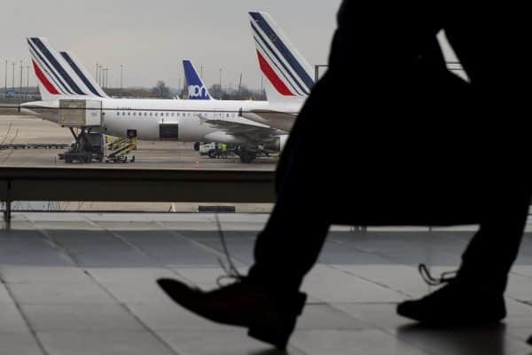 epa06623438 Travellers are silhouetted as they pass Air France airplanes sitting on the tarmac in Charles de Gaulle airport in Roissy, outside Paris, France, 23 March 2018. Approximately 30 percent of inbound and outbound Air France flights have been cancelled across France as part of a national Air France strike, which comes the day after a national strike day called by public sector workers and labor unions to defend labor rights and pensions.  EPA/IAN LANGSDON
