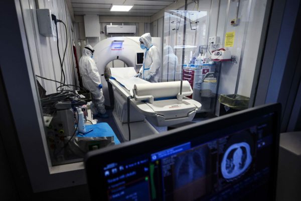 Healthcare workers wearing protective suits and masks work inside a "computerized axial tomography" CAT scan of the Covid Emergency Department of the Umberto I Hospital called "Fever Path" dedicated exclusively to COVID patients, during the pandemic emergency Coronavirus Covid -19 in Rome, Italy, 02 December 2020. ANSA/ANGELO CARCONI