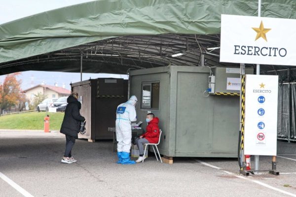 In una foto fornita dall'ufficio stmpa dell'esercito, addetto sanitari, che indossano tute e mascherine protettive, effettuano tamponi nel presidio del «Drive Throught Difesa» allestito sul parcheggio del'ospedale di Bolzano, 12 novembre 2020. Si tratta di una delle 200 postazioni allestite in tutta Italia su disposizione del Ministro Lorenzo Guerini, denominate Dtd "Drive Through Difesa" che potranno effettuare tamponi rapidi a favore della popolazione. ANSA +++ HO NO SALES - DITORIAL USE ONLY +++ o +++ ANSA PROVIDES ACCESS TO THIS HANDOUT PHOTO TO BE USED SOLELY TO ILLUSTRATE NEWS REPORTING OR COMMENTARY ON THE FACTS OR EVENTS DEPICTED IN THIS IMAGE; NO ARCHIVING; NO LICENSING +++