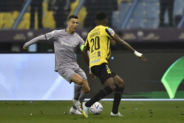 epa10431713 Al Nassr's Cristiano Ronaldo (L) in action against Al-Ittihad's Ahmed Sharahili during the Saudi Super Cup soccer match between Al-Ittihad and Al-Nassr in Riyadh, Saudi Arabia, 26 January 2023.  EPA/STR