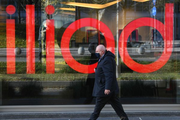 A person, with his face covered by a mask, walks by the window of an Iliad store in Milan, Italy, 17 novembre 2020. Iliad in Italy recorded a third-quarter increase in users compared to the previous quarter, with 580,000 new users registered between July and September 2020 and a quarterly turnover of 171 million euros that marks a +56% compared to the same period in 2019. ANSA/DANIEL DAL ZENNARO