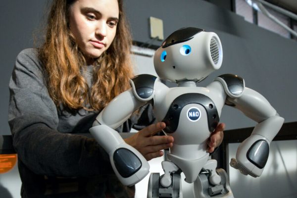 06 November 2018, Hamburg: An exhibition employee places the humanoid robot "NAO" in an area of the exhibition "Out of Office": When robots and AI work for us" at a press conference in the Museum der Arbeit. Until 19 May 2019, the exhibition will deal with the future of work and provide inspiration for dealing with robots and artificial intelligence (AI). Photo: Christian Charisius/dpa