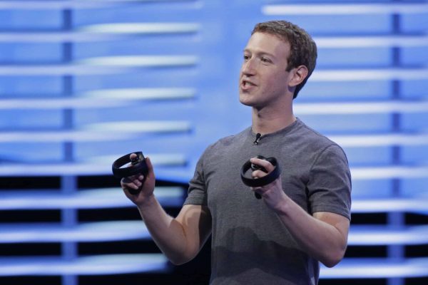Facebook CEO Mark Zuckerberg holds a pair of virtual reality handsets during the keynote address at the F8 Facebook Developer Conference Tuesday, April 12, 2016, in San Francisco.  Zuckerberg said Facebook is releasing new tools that businesses can use to build "chatbots," or programs that can talk to customers in conversational language.  (AP Photo/Eric Risberg)