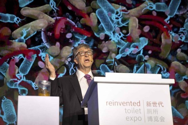 Bill Gates, former Microsoft CEO and co-founder of the Bill and Melinda Gates Foundation, speaks as a jar of human feces sits on a podium at the Reinvented Toilet Expo in Beijing, Tuesday, Nov. 6, 2018. With a jar of human feces on a podium next to him, billionaire philanthropist Bill Gates has kicked off a "Reinvented Toilet" Expo in China. Gates said Tuesday that the technologies on display at the three-day expo in Beijing represent the most significant advances in sanitation in nearly 200 years. (AP Photo/Mark Schiefelbein)