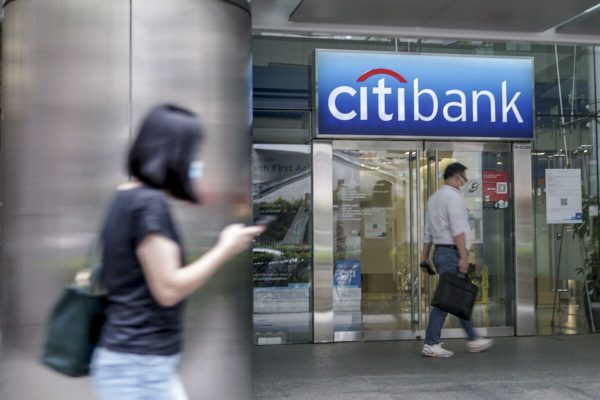 epa09139016 Pedestrians walk past a Citibank branch in Singapore,  16 April 2021. American bank Citigroup announced today that it will close its consumer banking operations in 13 markets across Asia, Europe, and the Middle East. It will retain its hubs in Singapore, Hong Kong, London, and the United Arab Emirates citing that it 'does not have the scale' to compete across the various countries.  EPA/WALLACE WOON