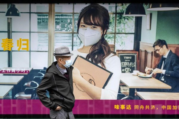 epa08331389 A man stands in front of the advertisement for a restaurant in Guangzhou, Guangdong province, China, 30 March 2020. China banned all foreign nationals entering the country from Friday 27 March, due to the fears of coronavirus reinfection from overseas. The outbreak of novel coronavirus, which causes the infection COVID-19, is calming down in China and continues worldwide.  EPA/ALEX PLAVEVSKI