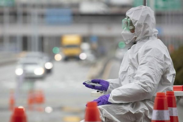 epa08282579 A medical staffer warms his hand with a hot pack amid the cold weather at a makeshift drive-thru (or drive-through) clinic in Seoul, South Korea, 10 March 2020, to check for coronavirus infections.  EPA/YONHAP SOUTH KOREA OUT