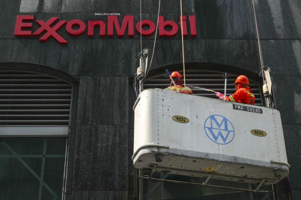 epa08264034 Cleaners work along the side of the ExxonMobil office building in Kuala Lumpur, Malaysia, 02 March 2020.  EPA/FAZRY ISMAIL