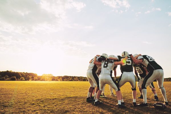 Group,Of,Young,American,Football,Players,Standing,In,A,Huddle