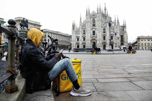 A rider that delivers food rests in Duomo (Cathedral) Square, Milan, Italy, 12 Mrch 2020.Tougher lockdown measures kicked-in in Italy on the day after Italian Premier Conte announced the day earlier that all non-essential shops should close as part of the effort to contain the coronavirus. All of Italy is on lockdown until 03 April due to the novel coronavirus crisis..ANSA/Mourad Balti Touati