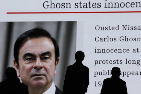 epa07269007 Pedestrians watch large-scale screen displaying a news program reporting on former Nissan Motor Co Ltd chairman Carlos Ghosn attending a court hearing at Tokyo district court, in Tokyo, Japan, 08 January 2019. Earlier in the day, Carlos Ghosn had his first hearing at the Tokyo District Court, his first public appearance since his arrest on 19 November 2018. According to reports, Ghosn stated that he was 'wrongly accused and unfairly detained'.  EPA/KIMIMASA MAYAMA