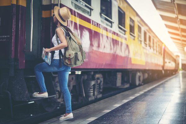 Happy female tourist at railway station on mobile map.Travel concept.