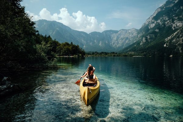 Young,Woman,Canoeing,In,The,Lake,Bohinj,On,A,Summer