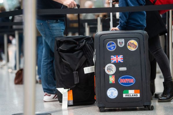 21 December 2020, North Rhine-Westphalia, Duesseldorf: A family queues with their luggage at the airport for a Corona test, while a British flag with the words "London" can be seen on the suitcase. Due to the emergence of a new, supposedly more contagious variant of the virus in the south-east of England, flights from the UK have been grounded as of today, although flights to the UK are continuing. Photo: Jonas Güttler/dpa