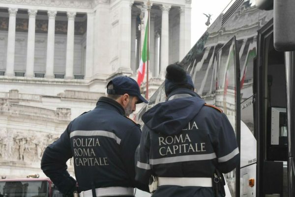 Agenti della polizia locale multano i pulman turistici parcheggiati a piazza Venezia che  protestano contro il nuovo regolamento comunale che vieta loro l'accesso nel centro storico a partire del 2019 a Roma, 20 dicembre 2018. ANSA/CLAUDIO PERI