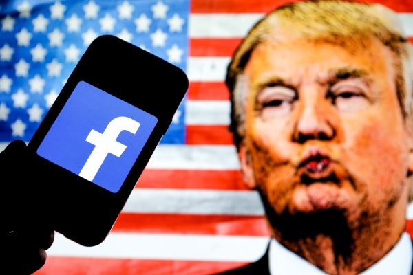 January 7, 2021, Poland: In this photo illustration the Facebook social media app company logo seen displayed on a smartphone, face of Donald Trump and the United States of America flag seen in the background. (Credit Image: © Filip Radwanski/SOPA Images via ZUMA Wire)