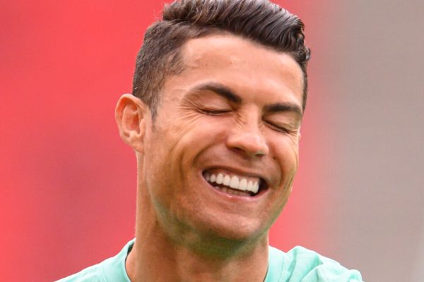 14 June 2021, Hungary, Budapest: Football: European Championship, Group F, before the match Hungary - Portugal, final training of Poprtugal in the Puskas Arena. Cristiano Ronaldo stands on the pitch and laughs. Photo: Robert Michael/dpa-Zentralbild/dpa