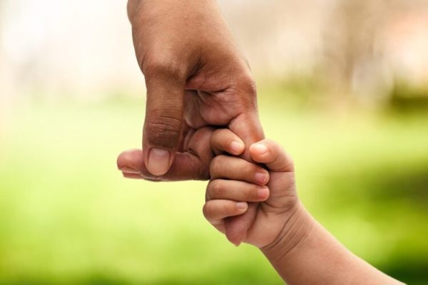 Closeup,Rear,View,Of,Mother,And,A,Child,Hands,Holding