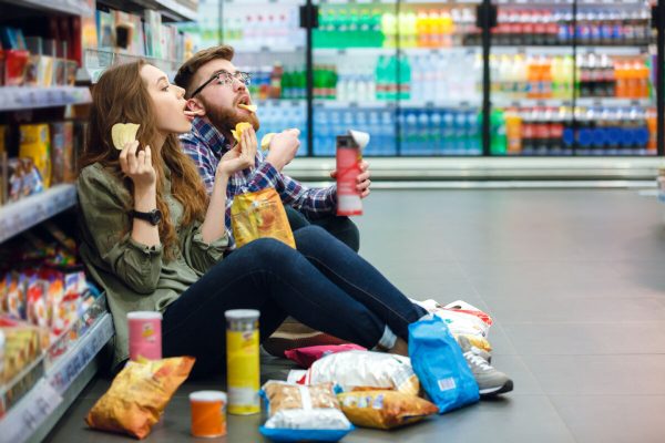 Portrait,Of,A,Young,Funny,Hungry,Couple,Sitting,On,The