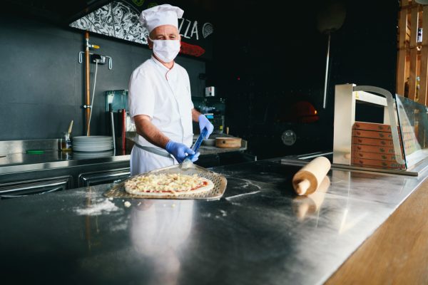 Skilled,Chef,Preparing,Traditional,Italian,Pizza,In,Interior,Of,Modern