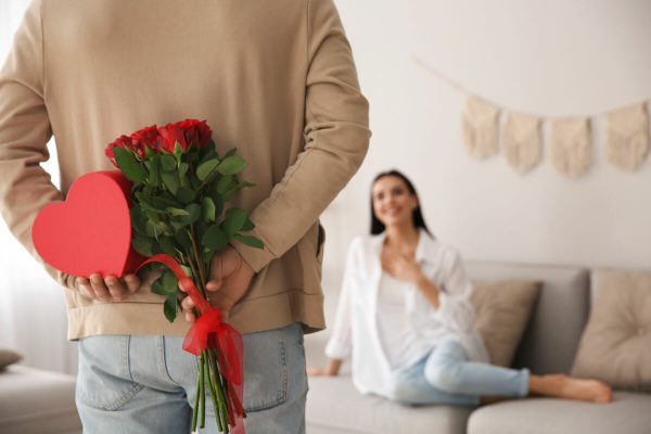 Man,Hiding,Beautiful,Bouquet,And,Gift,Box,Behind,His,Back