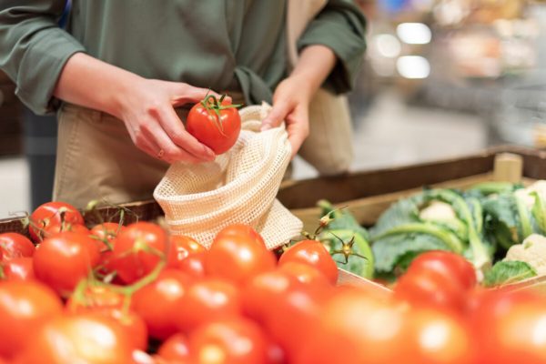 Girl,Holding,Mesh,Shopping,Bag,And,Cotton,Shopper,With,Vegetables