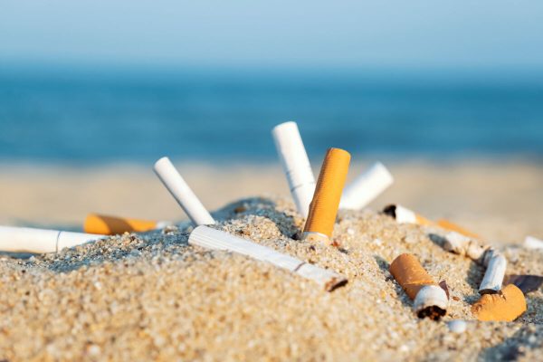 Cigarette,Butts,In,Yellow,Sand,On,Sea,Beach,On,Coast