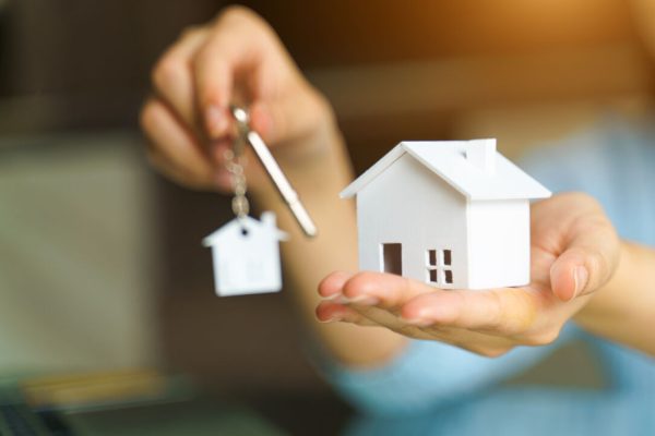Woman,Holding,White,House,Model,And,House,Key,In,Hand.mortgage