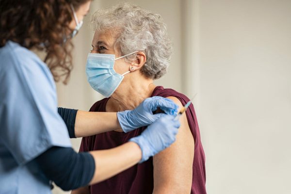 General,Practitioner,Vaccinating,Old,Patient,In,Clinic,With,Copy,Space.