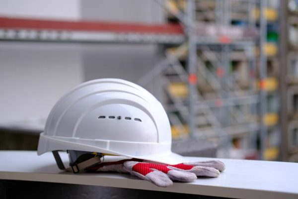 White,Hardhat,,Work,Gloves,,Helmet,On,Background,Of,Buildings,,Protection