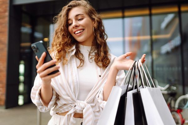 Smiling,Young,Woman,Shopper,Customer,Standing,On,City,Street,Holding