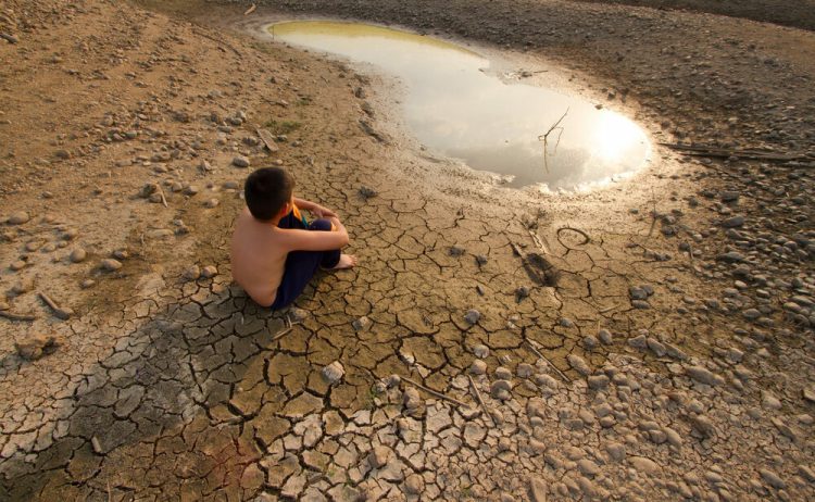 Water,Crisis,,Child,Sit,On,Cracked,Earth,Near,Drying,Water.