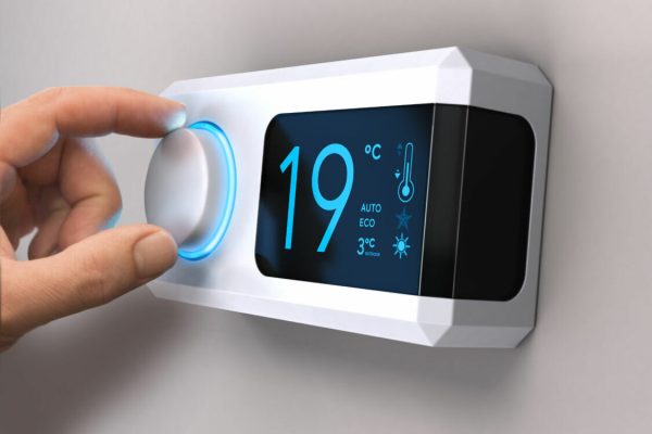 Hand,Turning,A,Home,Thermostat,Knob,To,Set,Temperature,On