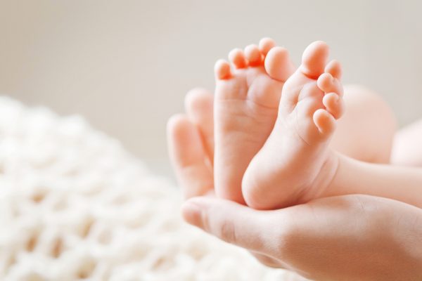 Baby,Feet,In,Mother,Hands.,Mom,And,Her,Child.,Happy