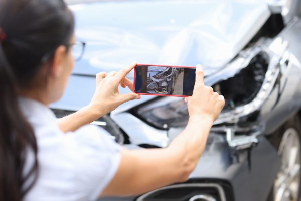 Woman,Agent,Takes,Pictures,Of,Damage,To,Car,After,Accident
