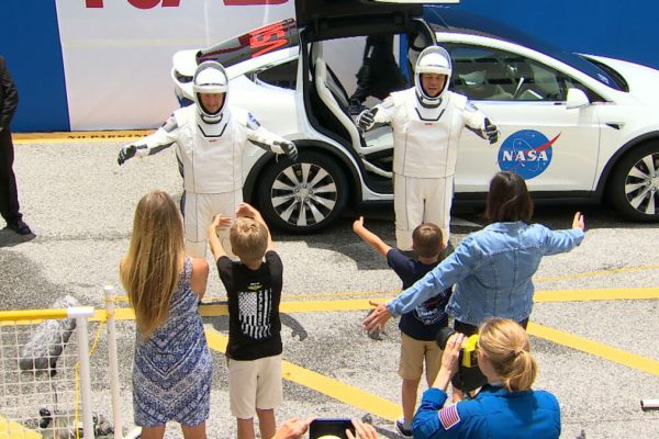 May 27, 2020 - Cape Canaveral, Florida, U.S. - SpaceX Demo-2 crew just walked out of the double doors below the Astronaut Crew Quarters, nd joined a rich legacy. Apollo and space shuttle crews exited through the same doors DOUGLAS HURLEY and ROBERT BEHNKEN just passed through on their way out to the customized Tesla Model X car that will be their ride to Launch Complex 39A. A carefully spaced crowd of family, friends and supporters cheered for the pair as they waved back and paused to speak to their wives and sons. (Credit Image: © NASA/ZUMA Wire/ZUMAPRESS.com)