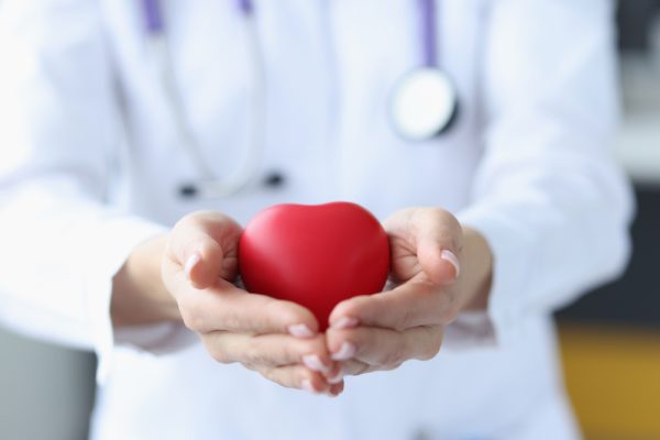 Female,Doctor,Holding,Red,Toy,Heart,In,Her,Hands,Closeup.