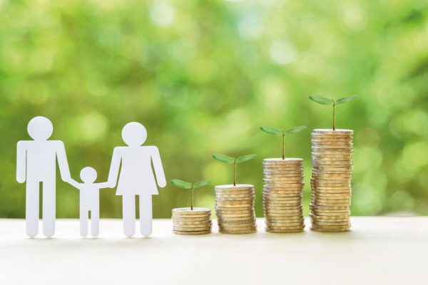 Family or child trust fund / fundraising concept : Family members, sprouts on coins on a table, depicts grantor establishes a trust fund to provide financial security to an individual e.g grandchild