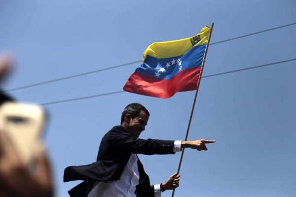 epa07413551 President of the Venezuelan National Assembly, Juan Guaido (C), waves a Venezuelan flag as he leaves the Maiquetia International Airport, in Caracas, Venezuela, 04 March 2019, after a tour in several South American counties.  EPA/Rafael Hernández