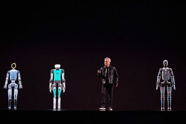 Jensen Wang sul palco del Ces di Las Vegas con i 14 robot umanoidi più avanzati.
