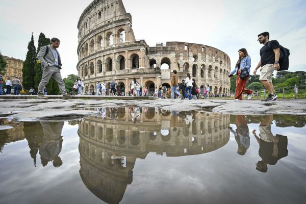 Turisti riflessi in una pozzanghera in piazza del Colosseo, Roma, 21 maggio 2023.
ANSA/ALESSANDRO DI MEO (generica, simbolica, transenna, transenne, degrado, lavori, cantiere, metro, c, turisti, turismo)