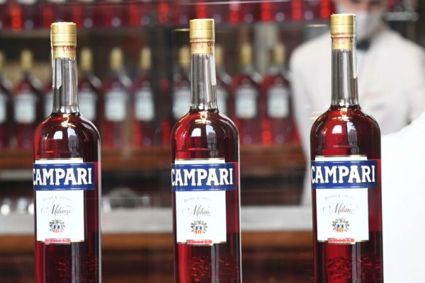 Bottiglie di Campari esposte sulla vetrina del bar Camparino in Galleria Vittorio Emanuele, Milano, 18 febbraio 2020.  Campari ha chiuso il 2020 con vendite nette per 1.772 milioni di euro, in calo del 3,8% sul 2019 (-4,1% a livello organico), con una flessione più sostenuta, il 7% a livello organico, nel quarto trimestre per effetto dei nuovi lockdown. L'utile netto, si legge in una nota, si è attestato a 187,9 milioni, in calo del -39,1% dopo rettifiche operative, finanziarie e fiscali per 14,2 milioni senza le quali il calo sarebbe stato contenuto al 24,4%. ANSA/DANIEL DAL ZENNARO