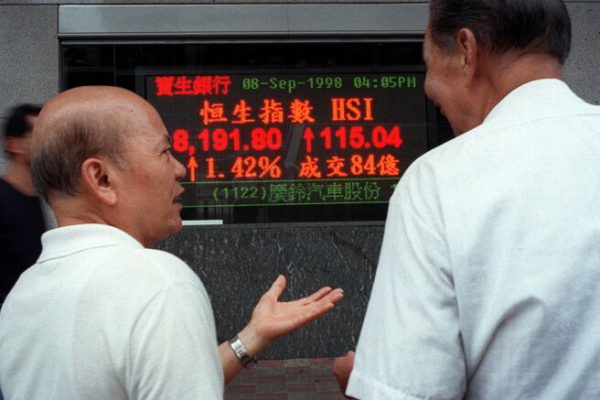 E26-19980908-HONGKONG (CINA): Two local men talk on the street in front of an electronic sign displaying the closing price of the key Hang Seng Index 08 Sept. Share prices again rose today 1.4 percent to a six week high of 8,189.25 after the Hong Kong government today called for a global plan to fight speculators.  PETER PARKS/ANSA/TO